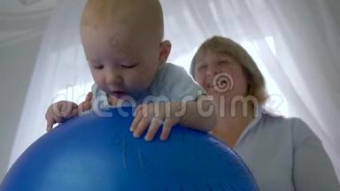 小病人躺在一个充气<strong>蓝球</strong>上，背景是专业治疗师室内背光